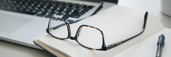 Glasses resting on an open notebook