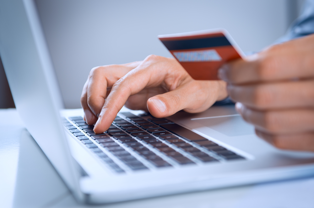 A person entering credit card information into a laptop